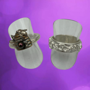 2 verschillende ringen van zilverklei. De eerste is rond met een bijenkorf en bij. De tweede ring is plat en breder, opgespoten met grillige lijnen.