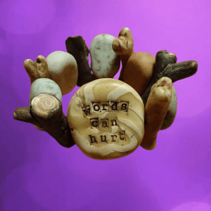 Botjes, takjes en stenen, allemaal van polymeerklei. Op de grootste steen staat Words can hurt.