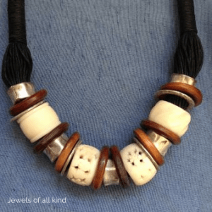 Een halssnoer van katoenen draden. Afgewisseld gebruik ik aluminium ringen, houten ringen en beenderen van polymeerklei.